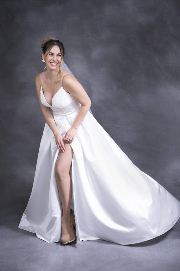 Vestido de novia ivory, largo, sin mangas, con cuello de pico y abertura en pierna. Talla 12